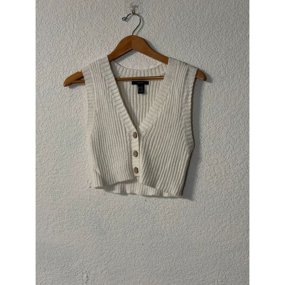 Cream colored ribbed sweater vest with wood brown buttons